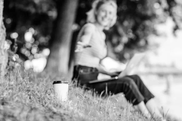 Свіжа кава. сучасна жінка з комп'ютером на вулиці. літо онлайн. Ранкова діаграма. Гарненька жінка п'є каву. дівчина п'є каву, щоб піти. Розслабся в парку. дівчина працює на ноутбуці . — стокове фото