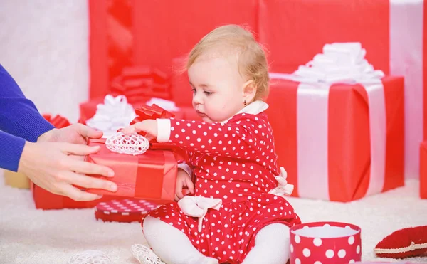 Sdílení radosti dítěte první Vánoce s rodinou. Kotě první Vánoce jednou za život události. Malé dítě hrát poblíž hromadu zalomený červené dárkové krabičky. Dárky pro dítě první Vánoce. Moje první Vánoce — Stock fotografie