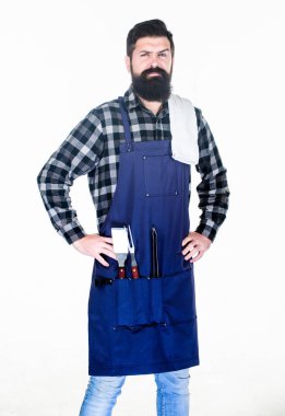 Erkeksi bir hobi. Sakallı hippi barbekü için önlük giyer. Kızartma ve ızgara yemek. Adam mutfak aletlerini barbeküde tutuyor. Açık havada et kızartmak için aletler. Piknik ve barbekü. Parkta et pişiriyorum.