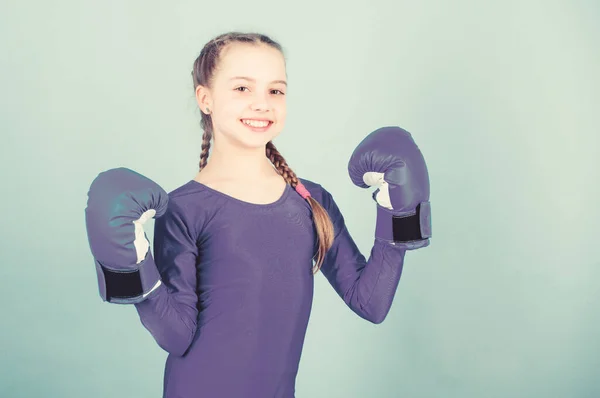Girl cute boxer on blue background. Rise of women boxers. Female boxer change attitudes within sport. Feminism concept. With great power comes great responsibility. Boxer child in boxing gloves