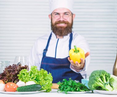 Şef pişirme tatlı biber. Adam mutfakta yemek önlük giymek. Adam pişirme tarifi sağlıklı biber sebze. Hobi ve profesyonel meslek yemek. Renkli mutfak. Vejetaryen diyet kavramı