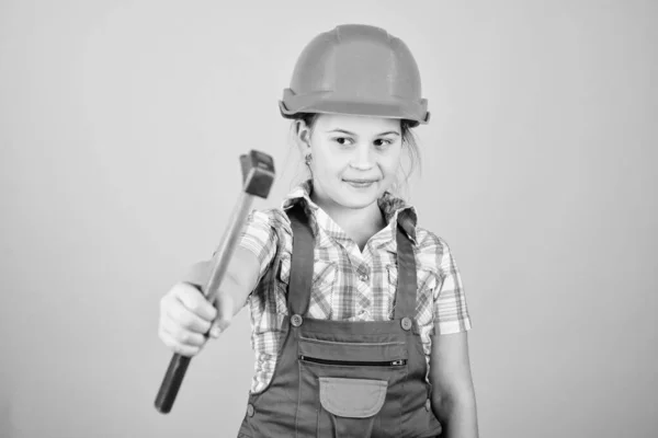 Il giorno del lavoro. 1 maggio. Ispettore capo. Riparazione. Esperto di sicurezza. Professione futura. riparazione bambina in officina. Bambina in casco con martello. Ragazzino con il cappello duro. Lavorare in officina — Foto Stock