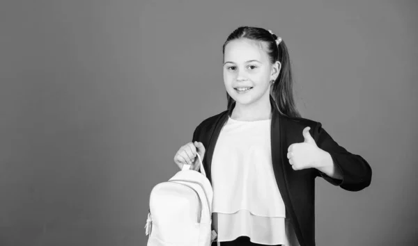 Μάθετε πώς ταιριάζει σωστά το σακίδιο. Κορίτσι μικρή μοντέρνα κούκλα μεταφέρουν σακίδιο. Ιδέα της μόδας των παιδιών. Μαθήτρια επίσημο στυλ ρούχα με μικρό χαριτωμένο σακίδιο. Μην ξεχάσετε το σακίδιο σας — Φωτογραφία Αρχείου