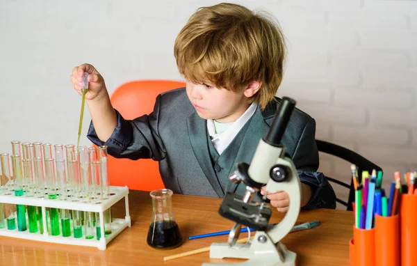 Um miúdo a aprender química no laboratório da escola. Cientista infantil estuda ciências. Um rapazinho na aula. Belo dia no laboratório. Um rapazinho na escola primária. Biologia equipamento de laboratório escolar — Fotografia de Stock