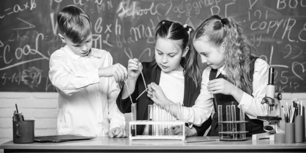 Teamwork concept. Reageerbuisjes met kleurrijke vloeistoffen. Studie van vloeibare toestanden. Groeps scholieren bestuderen chemische vloeistoffen. School laboratorium. Meisjes en jongen voeren experiment met vloeistoffen — Stockfoto