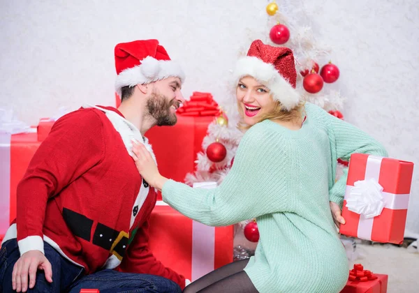 Couple in love happy enjoy christmas holiday celebration. Loving couple cuddle smiling while unpacking gift christmas tree background. Family prepared christmas surprise. Opening christmas present Stock Photo