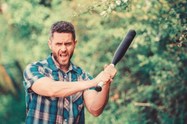 Adam traşsız sıkı yüz siyah beyzbol sopası tutun. Güçlü bir mizaç. İlke kavramı. Gücüne güveniyor. Cudgel ile doğada kabadayı adam. Vahşi enerji. Güç ve güç. Gücümü hisset.