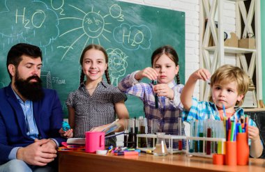 Okul kulübü. Okul eğitimi. Çocuğa kimyayı açıklıyor. Büyüleyici kimyasal reaksiyon. Sınıfta test tüpleri olan öğretmen ve öğrenciler. İlginç okul dersleri. Okulun kimya deneyi