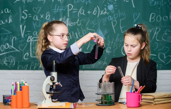 Pupillák aranyos lányok használnak kémcsöveket folyadékkal. Kémiai kísérlet koncepció. Biztonsági intézkedések a biztonságos kémiai reakció biztosítására. A zseniális gyerekek a saját kémiai elméletükön dolgoznak. Kémiai alapismeretek — Stock Fotó