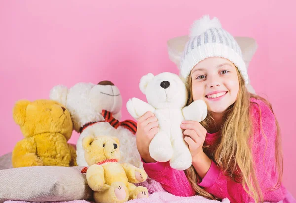 Kid little girl play with soft toy teddy bear on pink background. Bears toys collection. Child small girl playful hold teddy bear plush toy. Teddy bears help children handle emotions and limit stress