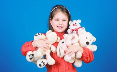 Küçük kız yumuşak oyuncak oyuncak ayı ile oynamak. Elinde bir sürü oyuncak var. Çocukluk kavramı. Oyuncak toplama hobisi. Çocukluk anılarını el üstünde tutuyorum. Küçük kız oyuncaklar ile yüz gülümseyen. Mutlu çocukluk