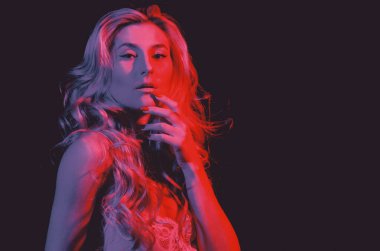 Onu bekliyorum. Kadını bodysuit'e bağla. Sarı kıvırcık saçlı. Pinup bak. Kırmızı ışıkta şehvetli bir kız. Erotik iç çamaşırı seksi kadın. Kadının moda portresi. Makyaj kozmetik ve cilt bakımı