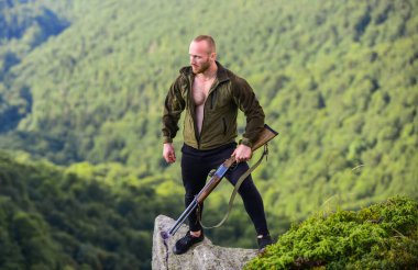 Kaçak avcı uçurumun kenarında duruyor. Kaçak avlanma kavramı. Adam vahşi kaçak avcı, silah ve doğal manzara. Avcı kaçak avcı kurban arıyor. Tüfek doğası olan bir avcı. Yasadışı avlanma