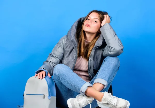 thoughtful mood. woman in beanie hat with backpack. warm winter clothing. shopping. flu and cold season. Leather bag fashion. girl in puffed coat. faux fur fashion. happy winter holidays