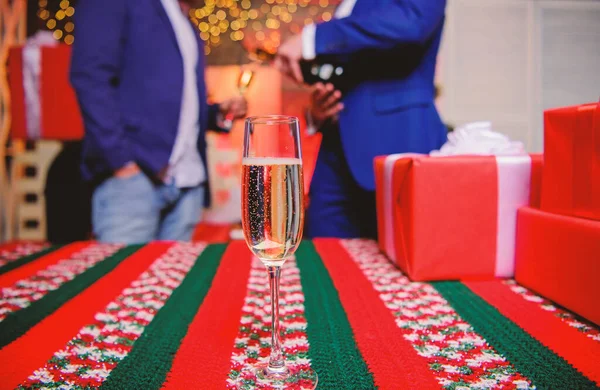 Champagne bicchiere elegante. Vino spumante ripieno di vetro o champagne vicino a scatole regalo. Società di anno nuovo. Un bicchiere di champagne da vicino. Attributo tradizionale di anno nuovo. Felice anno nuovo e buon Natale — Foto Stock