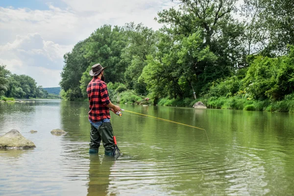 Insegna a pescare. Pesca sportiva all'aperto. hobby di pesca. Calmo e tranquillo. Pazienza e attesa. La pesca a mosca può essere considerata la più bella di tutti gli sport rurali. Pescatore cattura del pesce — Foto Stock