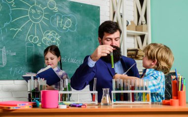 Okul sonrası kulüpleri farklı yerlerde çocuk yetiştirmek için harika bir yoldur. Anaokulu öğrencileri için kulüpler. Kimya deneyi. Öğretmen ve öğrencilerin test tüpleri sınıfta. Okul kulüpleri etkileşimli eğitim