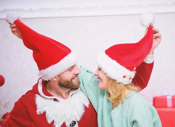 Jul gåva koncept. Par i kärlek njuta av julfirande. Par bär hattar som jultomten julgran bakgrund. Det är lätt att sprida glädje runt. Lycklig familj firar jul — Stockfoto