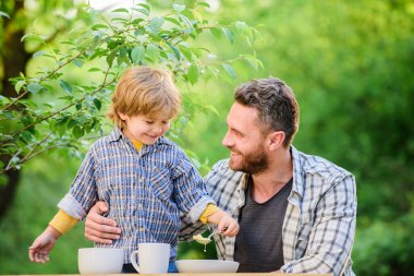 Mutlu aile birlikte. Çocuk gelişimi. çocukluk mutluluğu. Sağlıklı yemek ve diyet. Aile günü. Babalar günün kutlu olsun. Babası dışarıda olan küçük bir çocuk. Oğul ve baba sütlü yulaf lapası yiyor. Güzel yemek.