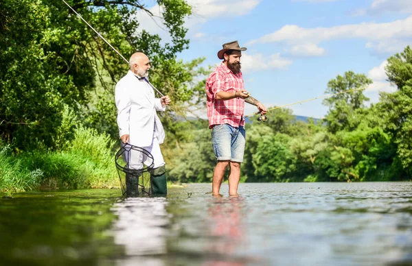 Friends fishing. Perfect weekend. Successful catch. Elegant bearded man and brutal hipster fishing. Hobby and recreation. Family day. Fishing team. Relax in natural environment. Summer vacation