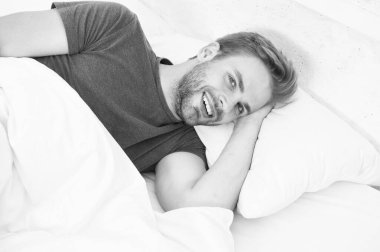 Büyük bir zevk yaşıyor. Sabah uyandıktan sonra gülümseyen bekar bir adam. Evde yatakta yatan bekar bir insan. Yatak odasında dinlenen bekar bir adam. Mutlu bekar bir hayatın tadını çıkarmak