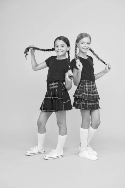 Amigos alegres. Meninas bonitos sorrindo fundo amarelo. Meninas pequenas felizes vestindo as mesmas roupas. Amigos desfrutando de amizade. Miúdos brincalhões. Felizes juntos. amigos da escola se divertindo juntos — Fotografia de Stock