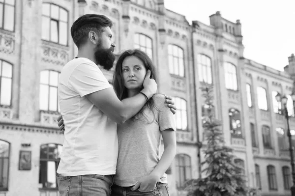 Två hjärtan fulla av kärlek. Sensuellt par i kärlek med att bygga på bakgrunden. Bearded man kramar bedårande kvinna med kärlek. Erotisk kärlek till hipster och sexig kvinna — Stockfoto