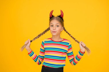 İçindeki küçük şeytan. Kızsal öfke. Şirin ama tehlikeli. Cadılar Bayramı konsepti Kırmızı boynuzlu küçük sevimli çocuk. Karnaval için aksesuarlar. Partiye hazırlanıyorum. Küçük şeytan. Oyuncu şeytan kız.
