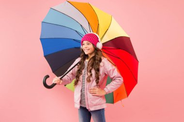 Entertain yourself. Fun concept. Feeling good. Girl having fun walking wireless headphones under colorful umbrella. Fall leisure. Music always with me. Every day fun. Child enjoying simple things