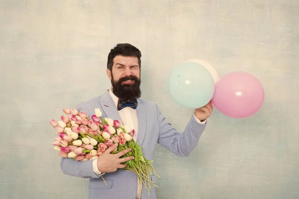 Flowers delivery. Gentleman romantic date. Birthday greetings. Confidence and charisma. Man bearded gentleman suit bow tie hold air balloons and bouquet. Gentleman making romantic surprise for her — Stock Photo, Image
