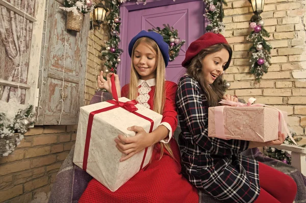 We believe in Santa Claus. Cute children open New Year presents. Festive celebration of xmas and New Year. Happy little girls unwrap gift boxes. Merry Christmas and Happy New Year