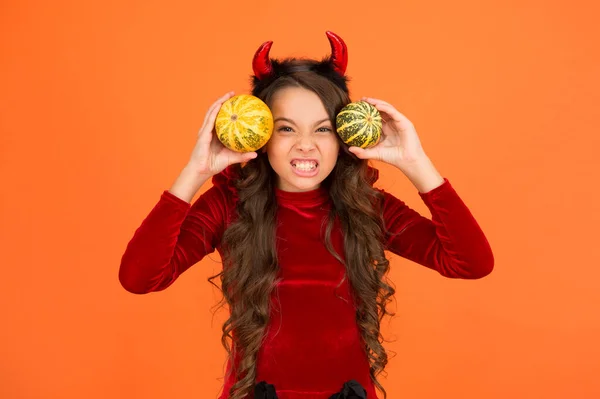 Veel plezier. Herfstvakantie. Pompoenen traditionele attribuut van herfstvakantie. Decoraties voor feestdagen. Speelse pooier. Meisje met hoorns speelt met pompoenen. Fijne feestdagen. Schattig kind vieren Halloween — Stockfoto