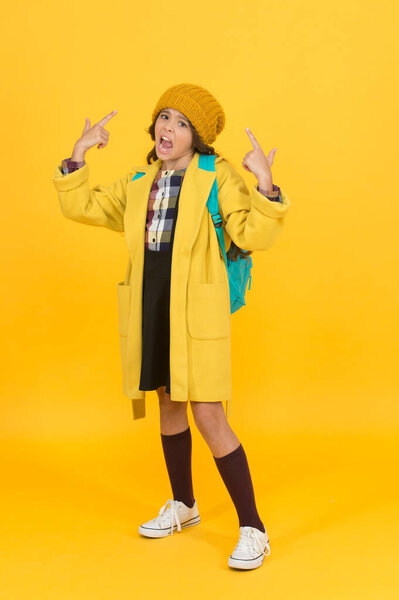 Listen to me. Unhappy small child hand gesturing on yellow background. Small schoolchild on autumn day. Small girl back to school. Adorable small child in autumn fashion