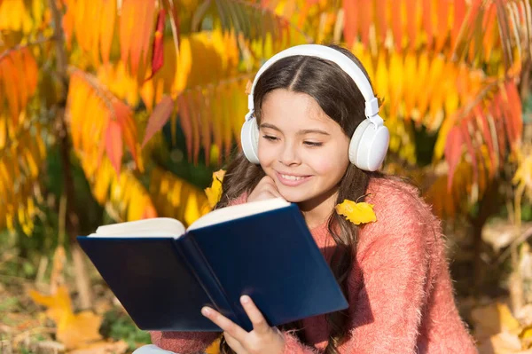 Visual and audio information. Schoolgirl study. Study every day. Girl read book autumn day. Little child enjoy learning at backyard. Kid study with book. Self education concept. Child enjoy reading