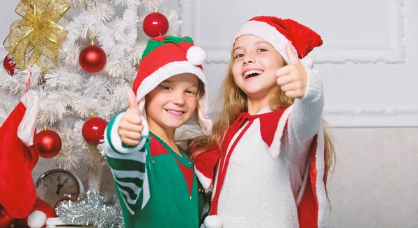 Kinder feiern fröhlich Weihnachten. Kinder Weihnachtskostüme Weihnachtsmann und Elfe. Wintermaskerade-Konzept. Geschwister feiern Weihnachten oder treffen sich zu Neujahr. Frohe Weihnachten. Familientraditionen — Stockfoto