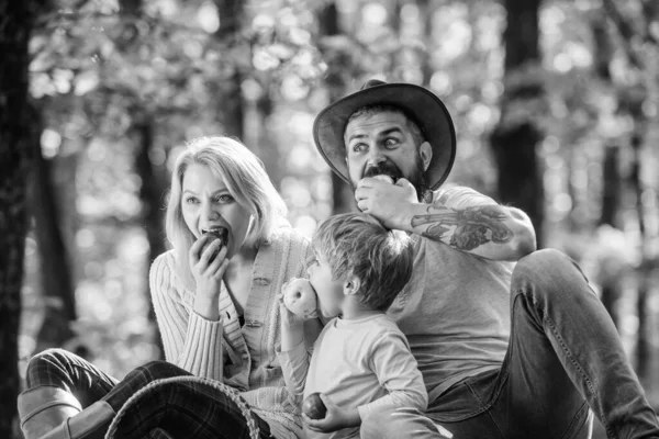 Gesundes Frühstück. Frühlingsstimmung. glücklicher Familientag. Mutter, Cowboy-Vater lieben ihren kleinen Jungen. Familienpicknick. sonniges Wetter. Gesunde Ernährung. Glücklicher Sohn mit Eltern entspannt im Herbstwald — Stockfoto