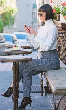 Sakin ol ve kahve molası. Arkadaş arama. Boş zaman kavramı. Kız moda Bayan smartphone ile. Kadın çekici şık esmer eğlence kafe teras arka plan harcamak. Keyifli zaman ve boş zaman etkinlikleri