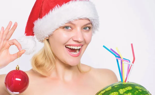 女孩圣诞老人帽子举行装饰球喝西瓜鸡尾酒。维生素营养和天然补充剂。冬季水果指南。女人喜欢西瓜鸡尾酒。圣诞节后排毒。西瓜饮食 — 图库照片