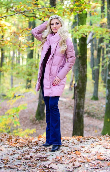 Beste kogeljassen om te kopen. Hoe je een kogelvrij vest moet dragen als een ster. Kogelvrij modeconcept. Een vrouw draagt een warm roze jasje. Meisje modieuze blonde lopen in de herfst bos. Jassen die iedereen zou moeten hebben — Stockfoto