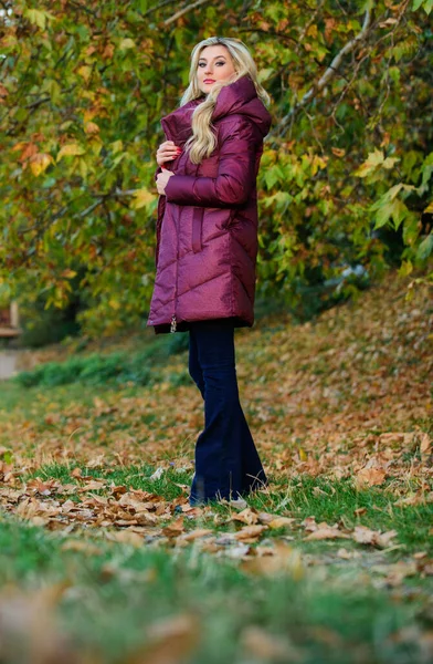 Jackor som alla borde ha. Bästa puffertkappa att köpa. Hur man plockar puffertkavaj. Ett renodlat modekoncept. Professionella stylist råd. Flicka fashionabla blonda promenad i höstparken. Kvinna bär varm jacka — Stockfoto