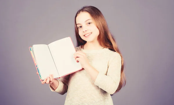 Aplikovat její znalosti z knihy na opravdový svět. Rozkošná malá holčička, která drží otevřenou knížku. Roztomilé malé dítě s knižní znalostí v rukou. Vědomostní dovednosti. Den znalostí nebo 1. září, kopírování místa — Stock fotografie