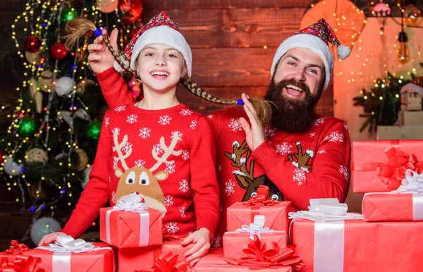 Come Santa Clause and dont delay. Father and child with gifts from Santa Claus. Father and daughter wearing Santa Claus hats. Happy family celebrate Christmas and new year. We believe in Santa Claus