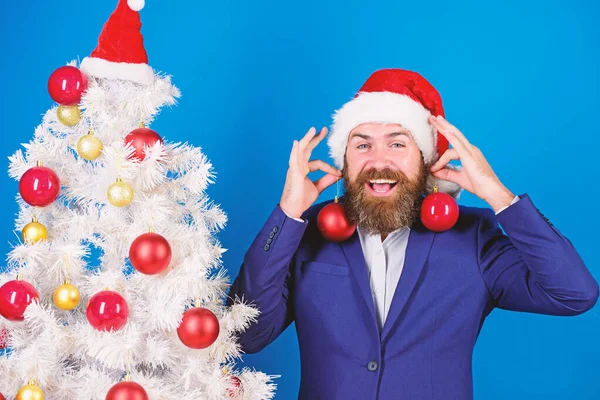 Vánoční zábava. Muž vousatý hipster nosí formální oblek a Santovu čepici. Obchodní a vánoční koncept. Santa držet vánoční míč dekorace. Prázdniny pro zábavu. Podnikatel se připojil k vánoční přípravě — Stock fotografie