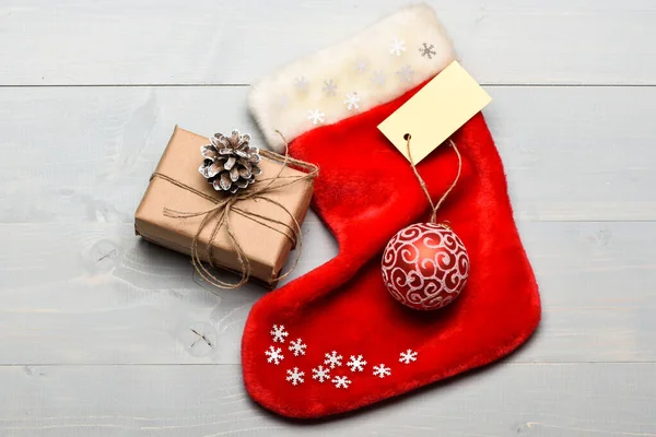 Houd familietradities. Kerst decoratieve sok licht achtergrond bovenaanzicht. Kerstsok in de vorm van een zak vullen met cadeautjes. Attributen van Kerstmis. Kerstman kous met kerst geschenkdoos — Stockfoto