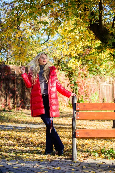 Девушка носит красный яркий теплый пиджак. Осенняя мода. Леди привлекательная модница, позирующая в пиджаке. Женщина модная блондинка с гримерным стендом в осеннем парке. Куртка для осеннего сезона — стоковое фото
