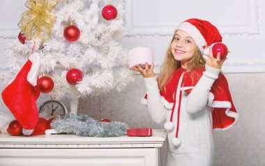 Çocuk kırmızı ile Noel ağacı süsleme süsler topları. Aziz tatil aktivitesi. Santa şapka Noel ağacı süsleme evlat. Aile geleneği kavramı. Kız çocuk dekorasyon Noel ağacı