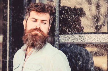 Erkeklik ve erkeklik. Yakışıklı adamın kendine güvenen duruşu. Uzun sakallı erkeksi bir görünüm. Berber konsepti. Sakal tımarı. Sakal bakımı. Adam çekici sakallı hipster açık havada poz