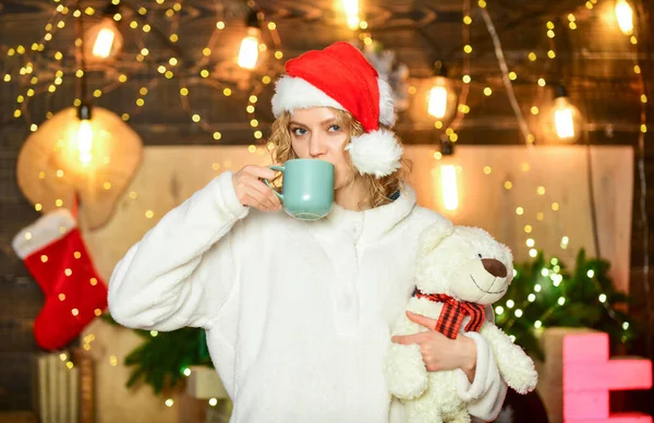 Oyuncak kadın hediye. Noel Baba şapkalı kız çay içer. Kahve zamanı. Süveter giymiş neşeli bir kadın. Burada olmaktan mutluyum. Kış tatili kutlaması. Mutlu yıllar. Noel hazırlığı. Xmas havası — Stok fotoğraf