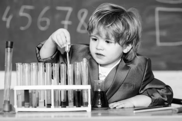 Mały chłopiec na lekcji. Wróć do szkoły. Mały chłopiec w szkole podstawowej. naukowiec szkoły dziecko studiuje nauki. Little Kid nauka chemii w szkole laboratorium. Nowe pomysły na medycynę — Zdjęcie stockowe