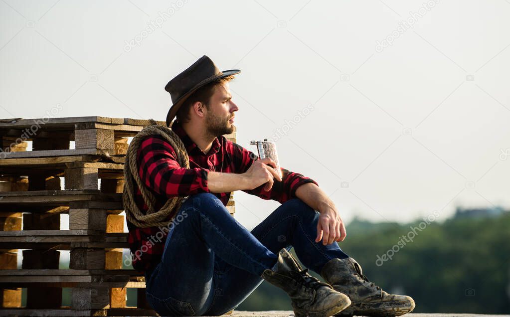 great story. cowboy with lasso rope. Western. man checkered shirt on ranch. western cowboy portrait. Vintage style man. Wild West retro cowboy. wild west rodeo. Thoughtful man in hat drink whiskey